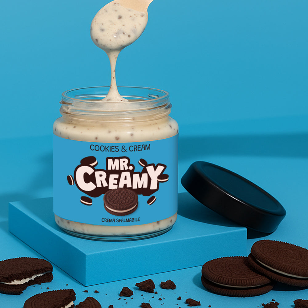 Confezione da 200g di crema spalmabile Mr Creamy al Cookies & Cream mentre viene sollevata da un cucchiaino