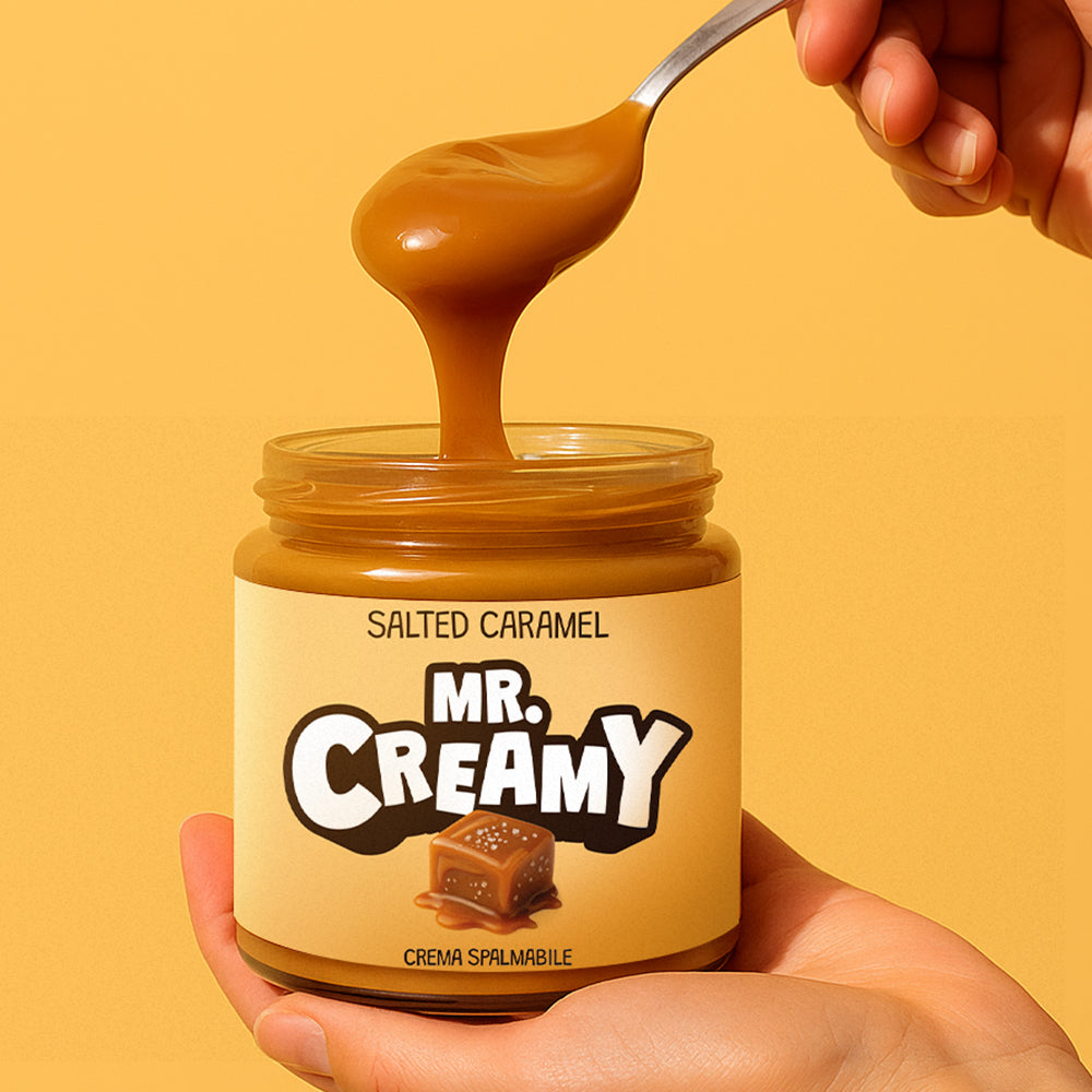 Confezione da 200g di crema spalmabile Mr Creamy al Salted Caramel mentre viene sollevata con un cucchiaino