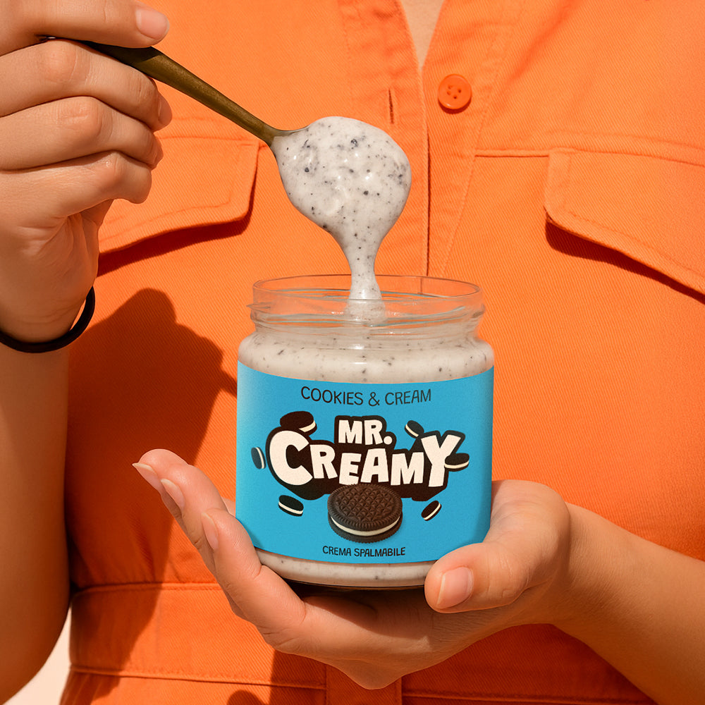 Confezione da 200g di crema spalmabile Mr Creamy al Cookies & Cream mentre viene sollevata con un cucchiaio 
